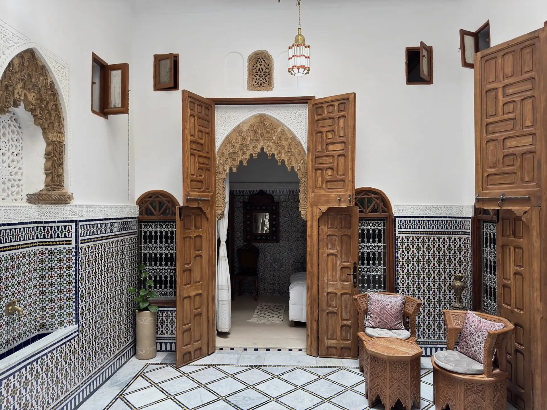 Les portes de cèdre du patio, sous leurs arcs de plâtre sculpté