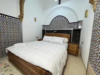 Un lit sous un arc de plâtre sculpté